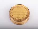a close up of a small gold box on a white surface