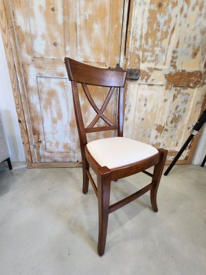 a wooden chair with a white seat in front of a wooden door