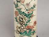 an image of a tall vase with a bird and flowers on it