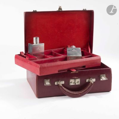 une valise rouge contenant un flacon de parfum