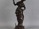 une statue en bronze représentant une femme tenant un oiseau dans la main