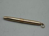 a gold colored metal pen with a keychain on a table