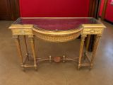 une console ancienne avec un plateau en verre et des finitions dorées