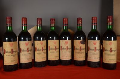 six bottles of red wine lined up on a red table