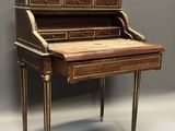 an antique writing desk with a wooden top and gold trimming