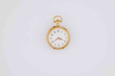 a close up of a pocket watch on a white surface