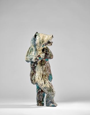 un gros plan d'une sculpture représentant un ours sur une surface blanche
