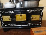a black and yellow stove with pots and pans on it