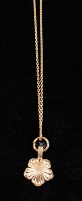 a close up of a gold necklace on a black background