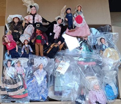 une boîte remplie de poupées posées sur le sol