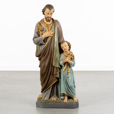 the statue of jesus holding a child is standing next to a statue of a woman