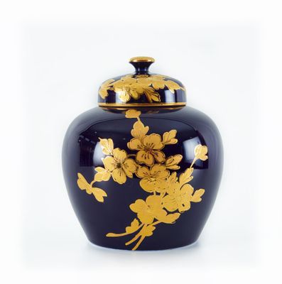 un vase noir orné de fleurs dorées