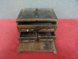 a small wooden box with two drawers on top of it