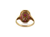 a close up of a gold ring with a ruby stone