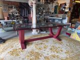 a glass table with a red base in a room