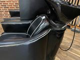 black leather reclining chair with a sink in the middle of it