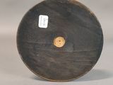 a wooden object with a button on it on a table