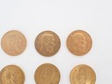 six different types of gold coins on a white surface