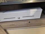 a white cash box sitting on top of a wooden cabinet