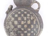 an old vase with a checkered design on it