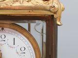 a gold clock with a white face and gold hands