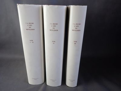 trois livres blancs empilés les uns sur les autres sur une table