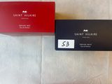 deux boîtes de parfum posées l'une à côté de l'autre sur un lit