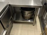 une cuisine en inox avec une grande casserole posée sur le plan de travail