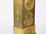 an image of a gold clock on a white surface with a white background