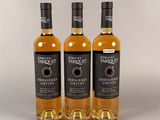 trois bouteilles de whisky, dont une avec une étiquette noire et une autre avec une étiquette blanche
