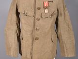 une vieille veste militaire posée sur un mannequin, ornée d'une médaille