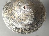 a silver plate with a bird on it on a table