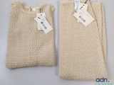 two bags with tags on them sitting on a white surface