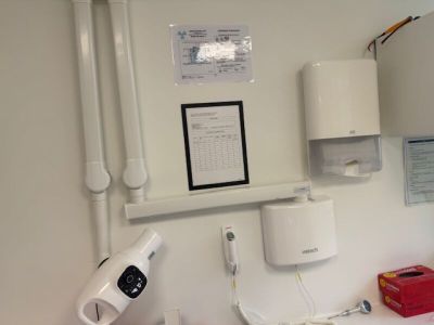 a bathroom with a sink, mirror, toilet, and other items on the wall