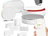 une personne tenant un smartphone devant tout un tas de gadgets