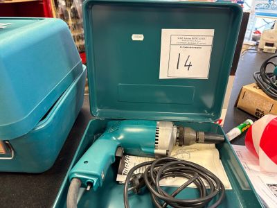 une boîte bleue contenant une perceuse, posée sur une table