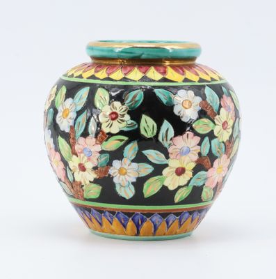 un vase noir orné de fleurs colorées sur fond blanc