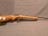 un vieux fusil avec une poignée en bois sur un fond gris