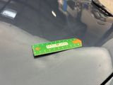 a green ruler on the hood of a car