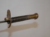 a close up of a sword on a white surface