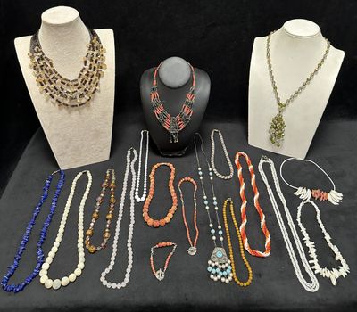 many necklaces and bracelets on display on a table