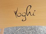 a close up of a wooden chair with the word yoghi written on it