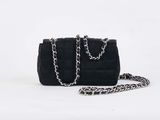 black quilted purse with chain strap on white background