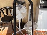 a vacuum and a fan on the floor next to a chair