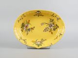 an image of a yellow plate with flowers on it on a stand