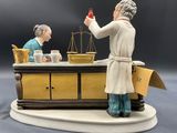 a figurine of a woman and a man at a table