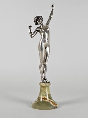 une statue en argent représentant une femme tenant une fleur à la main