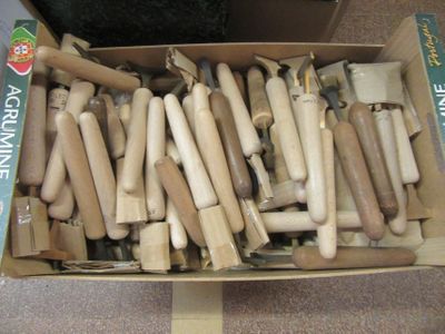 a cardboard box full of wooden tools on the floor