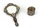 une image représentant un petit miroir et une bague sur une surface blanche
