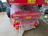 un gros plan sur un tracteur rouge avec plusieurs sacs à l'arrière